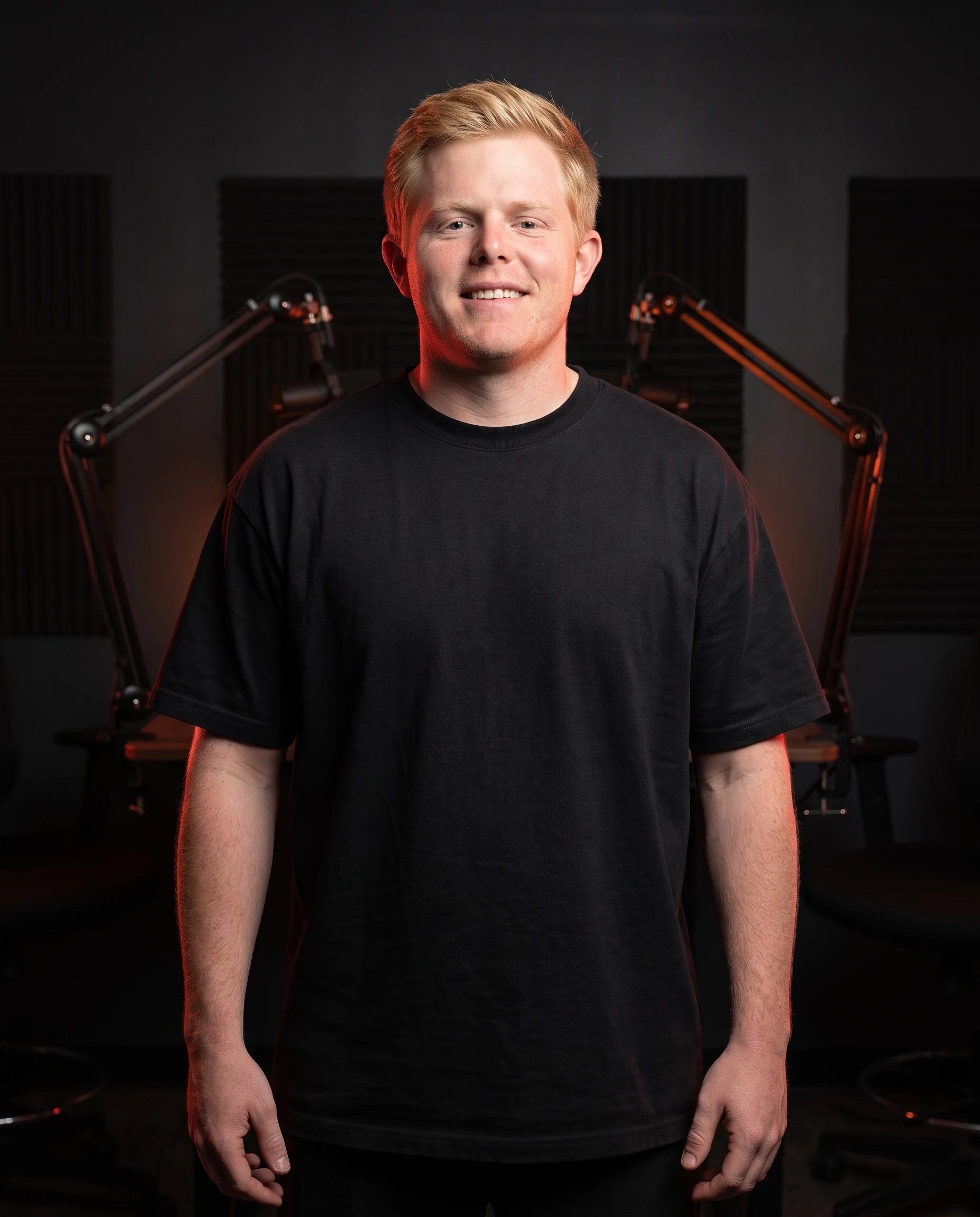 Eddie modeling an unbranded black heavyweight T-shirt concept in a podcast studio.