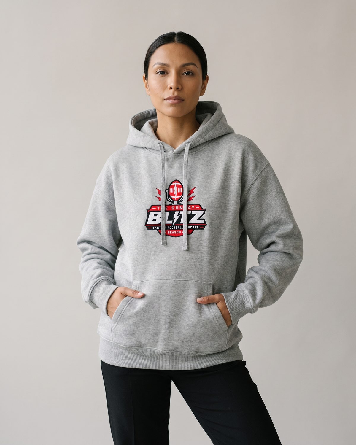 Woman in the heather grey Crest Fleece Hoodie with her hands in the pocket